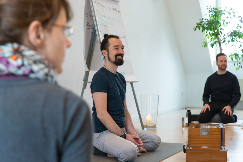 Alexander Kröker auf Yogamatte mit Harmonium und Flipchart bei Yoga Ausbildung Yin im Studio Berlin Yogaausbildung Yin Weiterbildung