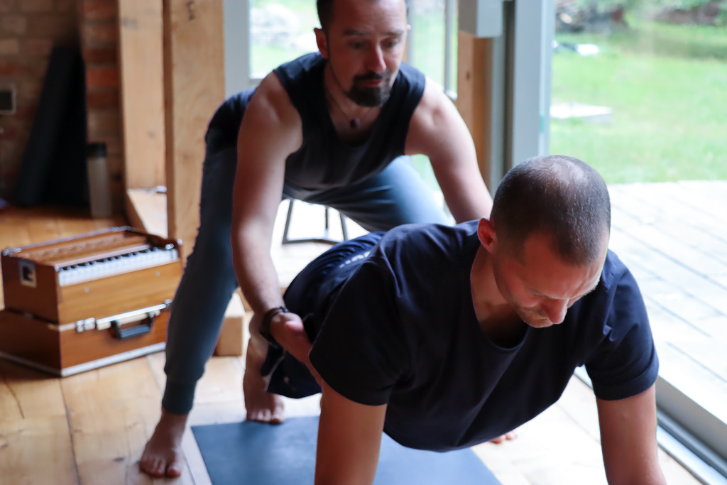 Yogalehrer Alex Kröker mit Yogaschüler unterstützt bei Asana gemeinsam Yogalehrer Berlin Weiterbildung Fortbildung